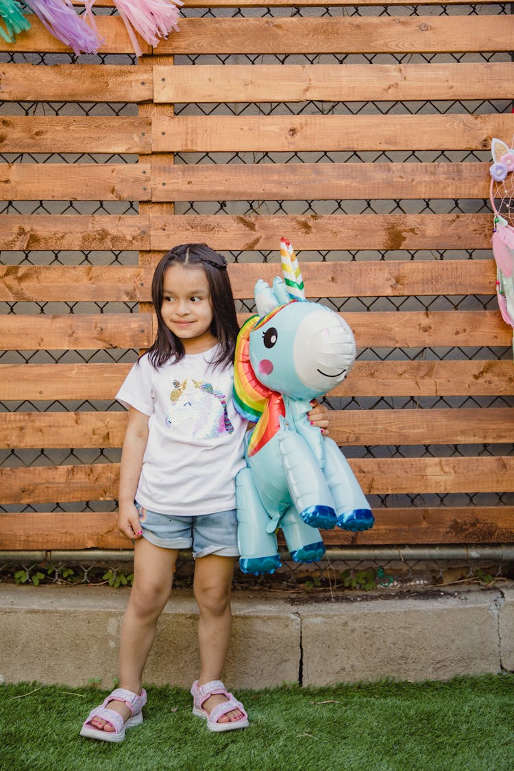 Cute Girl Holding A Pony Plush Toy