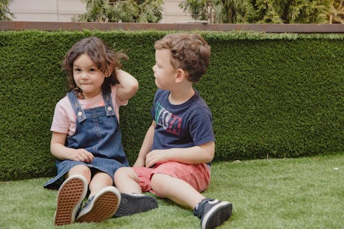 Boy and Girl Sitting on Grass