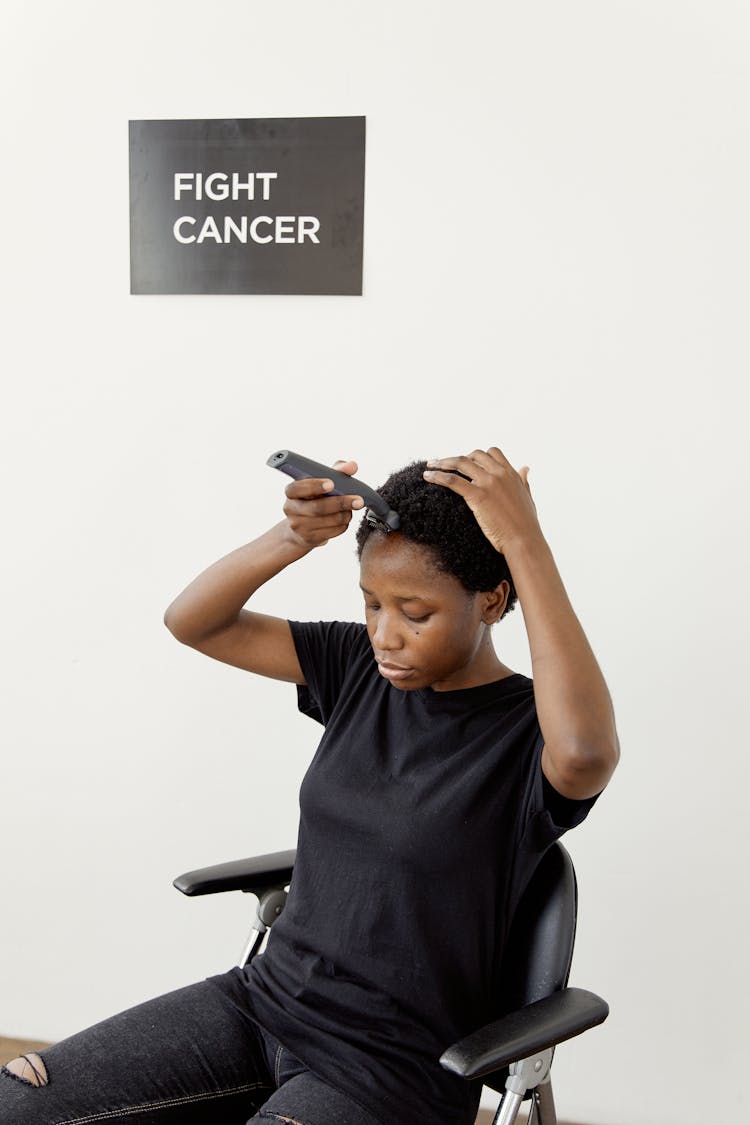 Woman Sitting On Chair Shaving Her Hair