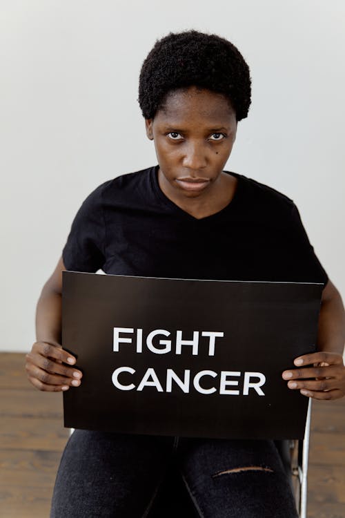 Woman Sitting in Black Shirt Holding a Poster