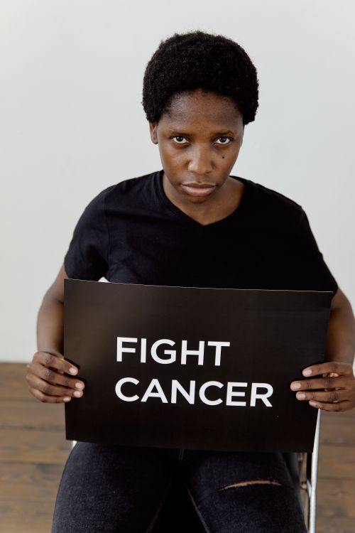 Free A black woman holding a 'Fight Cancer' sign, promoting awareness and advocacy. Stock Photo
