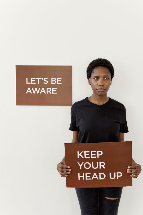 Free Portrait of woman promoting awareness with encouraging signage. Stock Photo