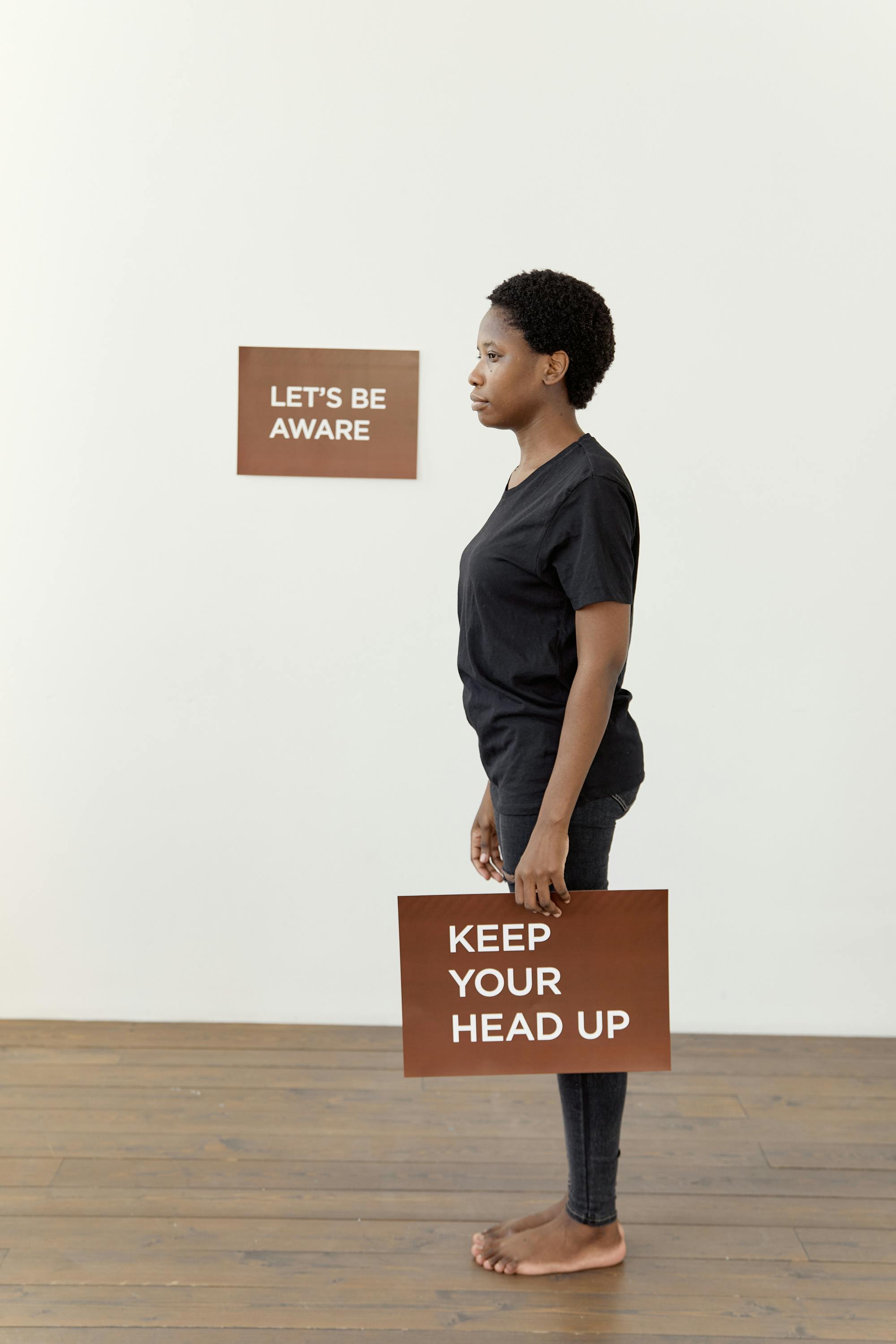 African American woman holds sign with an inspiring cancer awareness message.