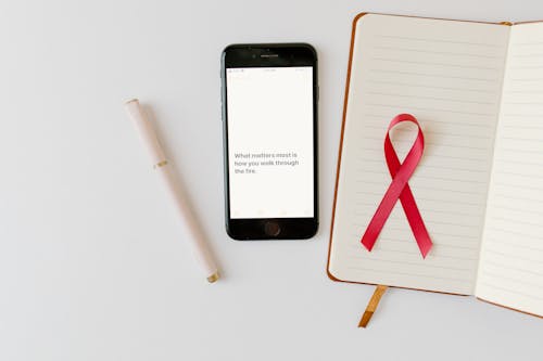 Free Smartphone beside a Journal with Red Ribbon  Stock Photo