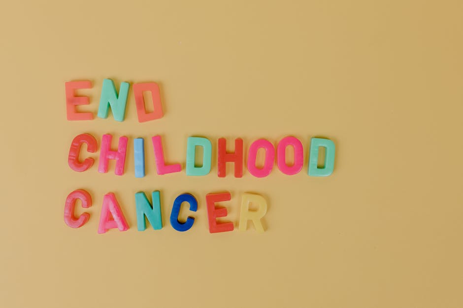 Colorful letters spelling 'End Childhood Cancer' on a yellow background promoting cancer awareness.