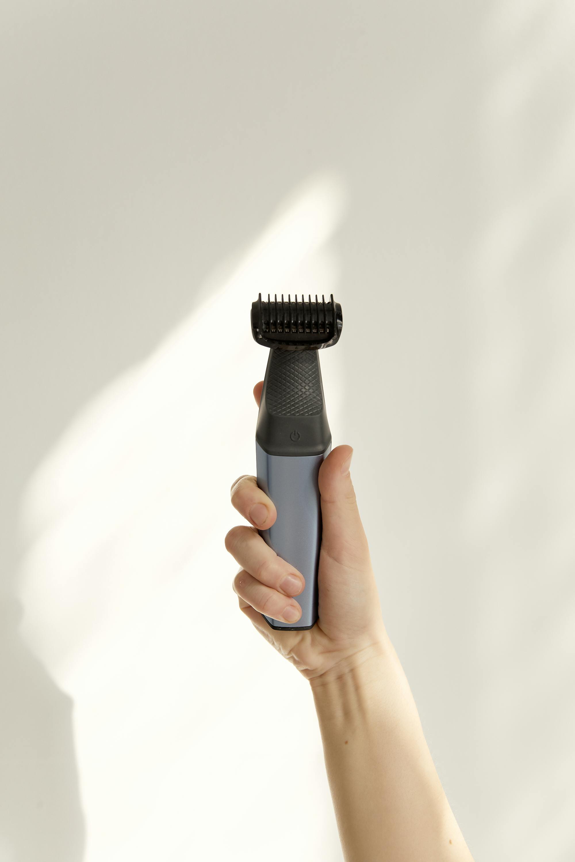 A woman holding an electric shaver in her hand