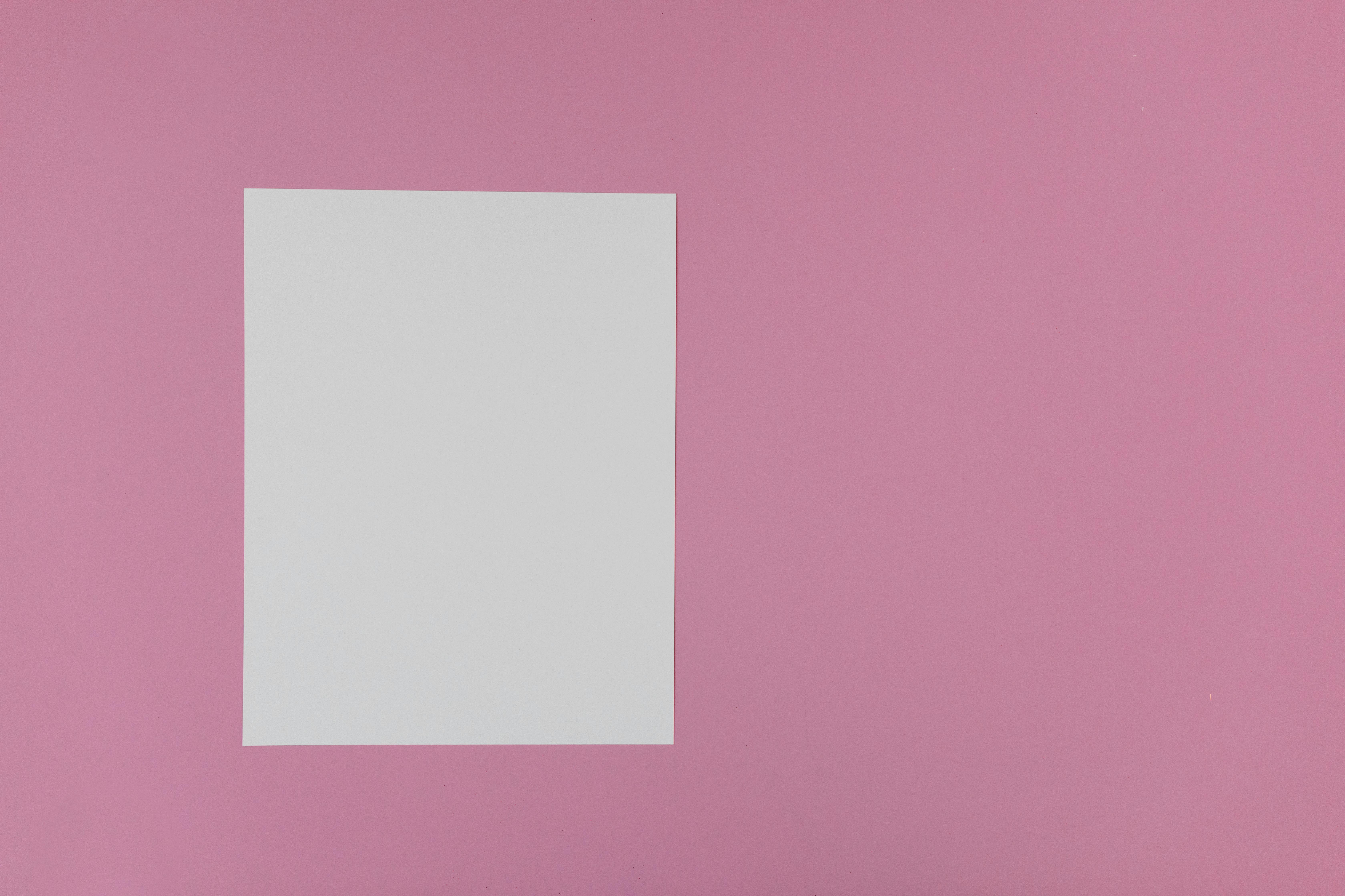 Blank white paper centered on a vibrant pink background, perfect for design mockups.