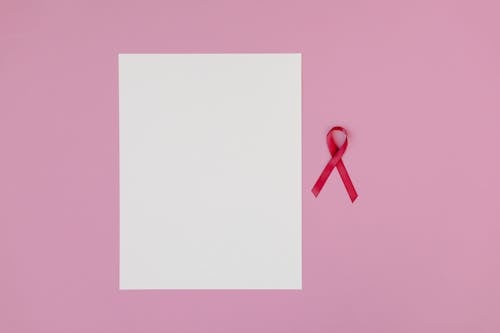Blank White Paper Beside a Red Ribbon in Pink Background