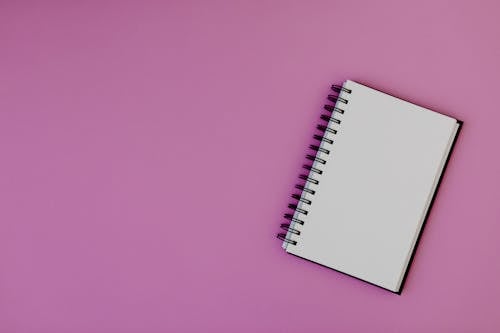 White Spiral Notebook on Pink Background