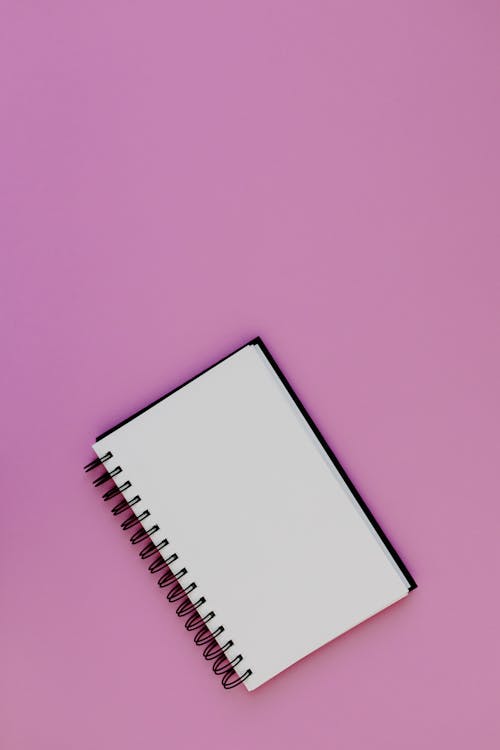 Free An Empty Notebook on a Purple Background Stock Photo