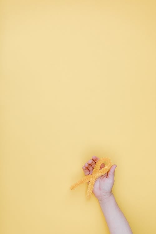 Kostnadsfri bild av canceroffer, gult band, hand