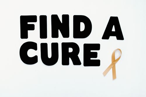 Free Conceptual image featuring 'Find a Cure' text with a cancer awareness ribbon on a white background. Stock Photo