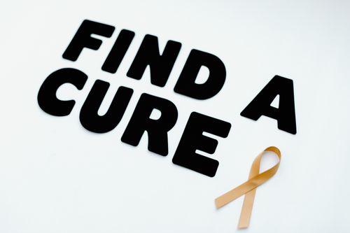 Free Image of a gold awareness ribbon with the message 'Find a Cure' on a white background. Stock Photo