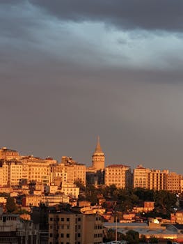 Stunning view of Istanbul's Galata Tower at sunset under dramatic clouds.