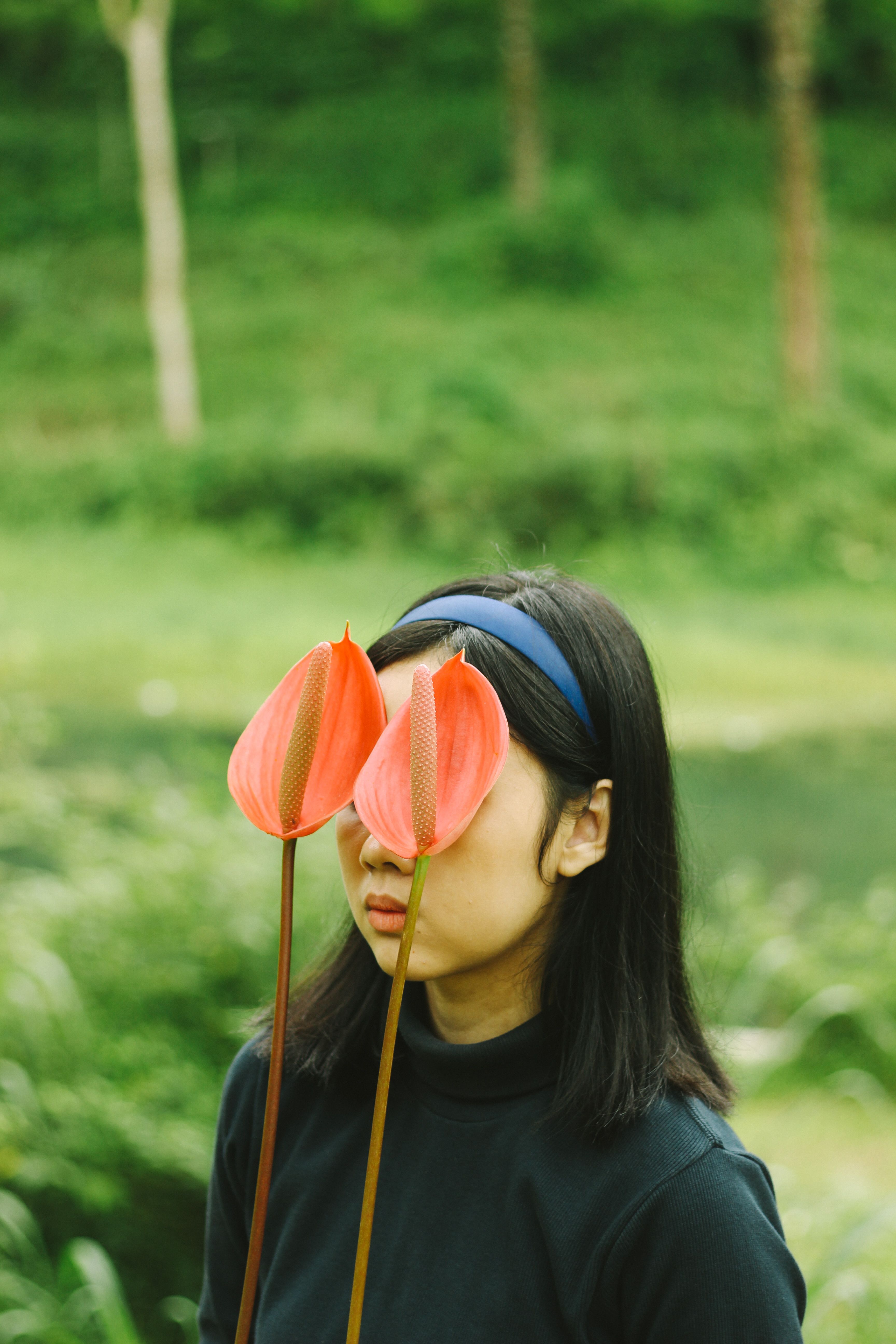 A Woman Standing in the Garden with Flowers Covering Her Face · Free ...