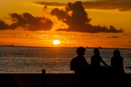 Free Silhouettes of people against a stunning Bahia sunset over the Atlantic Ocean. Stock Photo