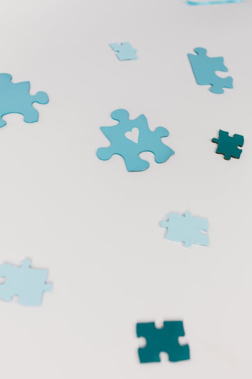 Blue Puzzle Pieces on White Surface