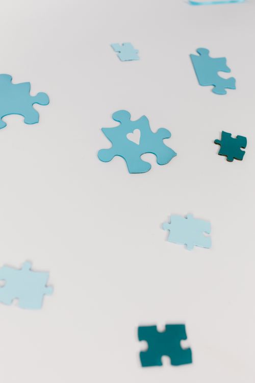 Free Scattered blue puzzle pieces on a minimal white surface. Perfect for themes of teamwork and problem-solving. Stock Photo