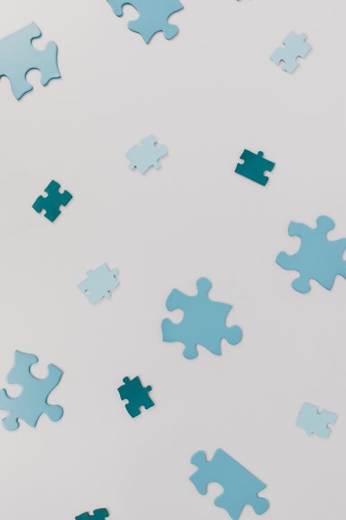 Free Close-up of varied blue puzzle pieces scattered randomly on a white surface. Stock Photo