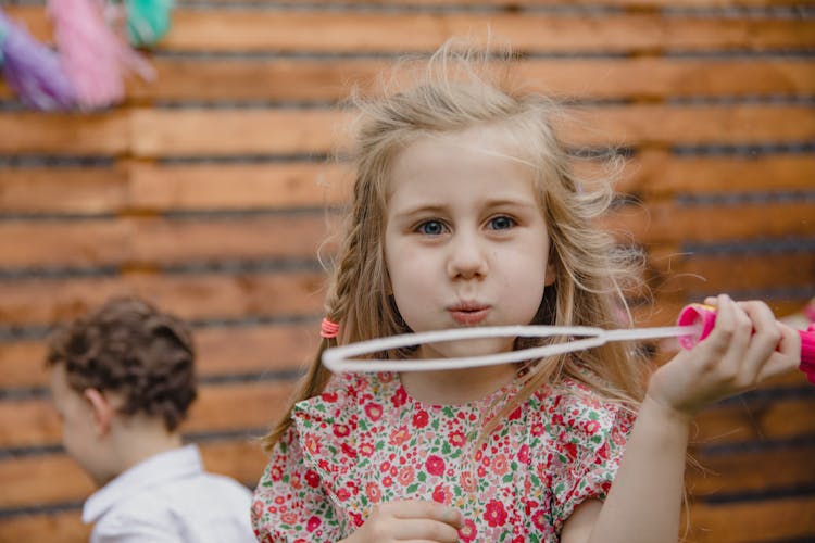 Close Up Photo Of A Girl Blowing Bubble Soap