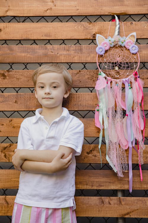 Cute Young Boy standing beside a Colorful Dream Catcher 