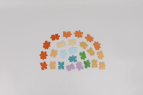 Free A collection of diverse colored puzzle pieces arranged on a white backdrop. Stock Photo