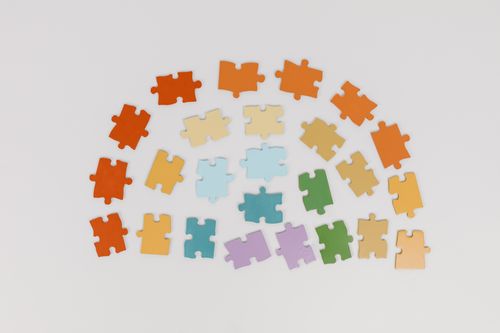 Free A collection of colorful jigsaw puzzle pieces arranged in a semicircle on a white background. Stock Photo
