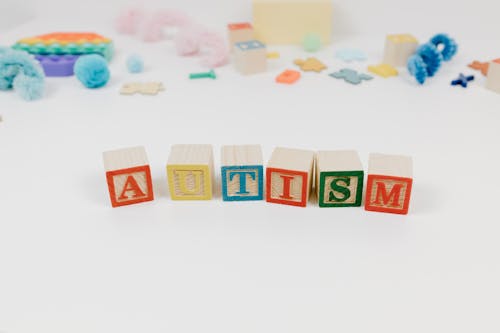 Letter Blocks Near Toy Pieces on the White Background