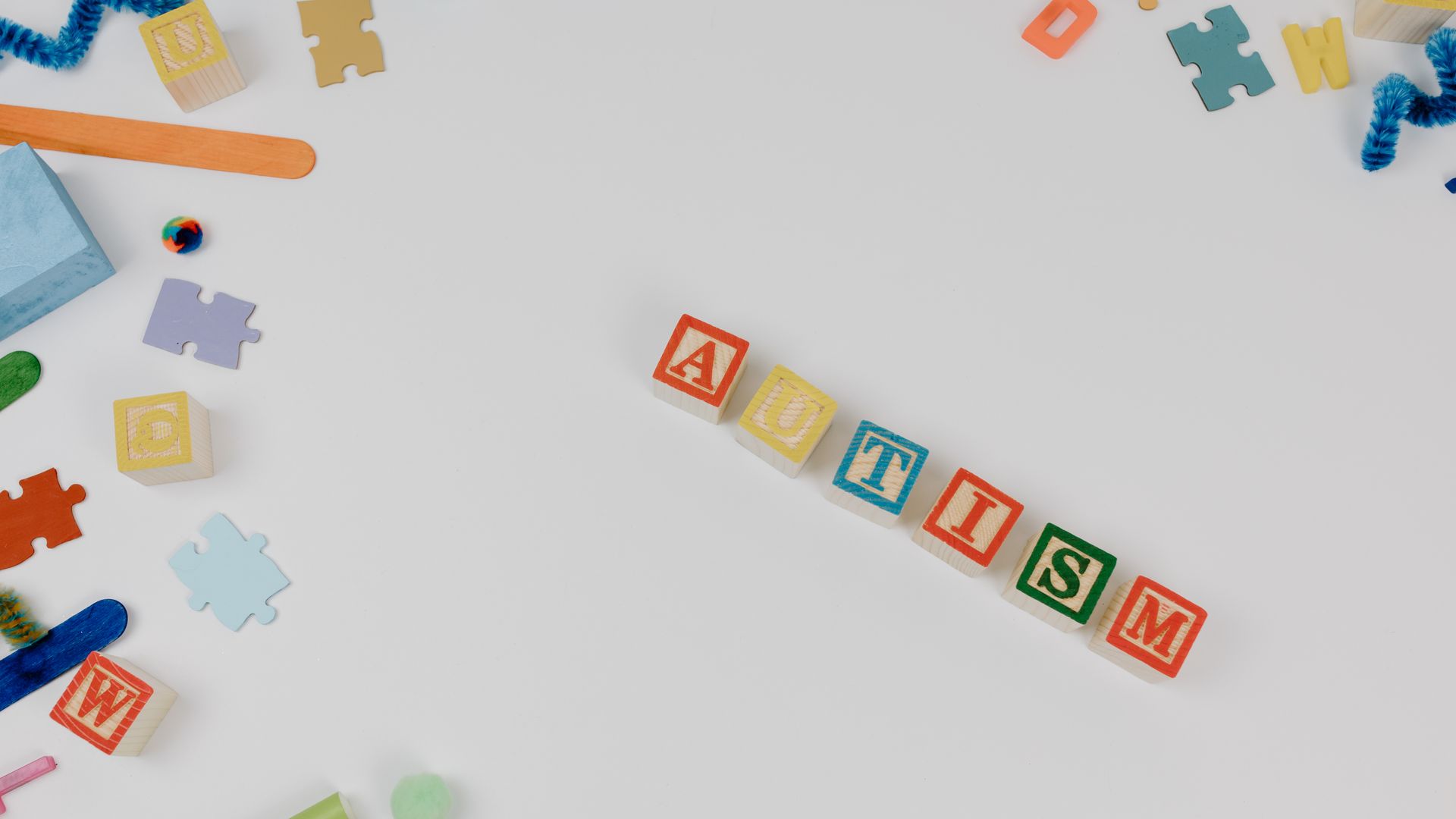 Modafinil for Autism Related Fatigue: Exploring the Benefits Flat lay of autism awareness elements with colorful puzzle pieces and blocks on a white background — modafinil for autism related fatigue