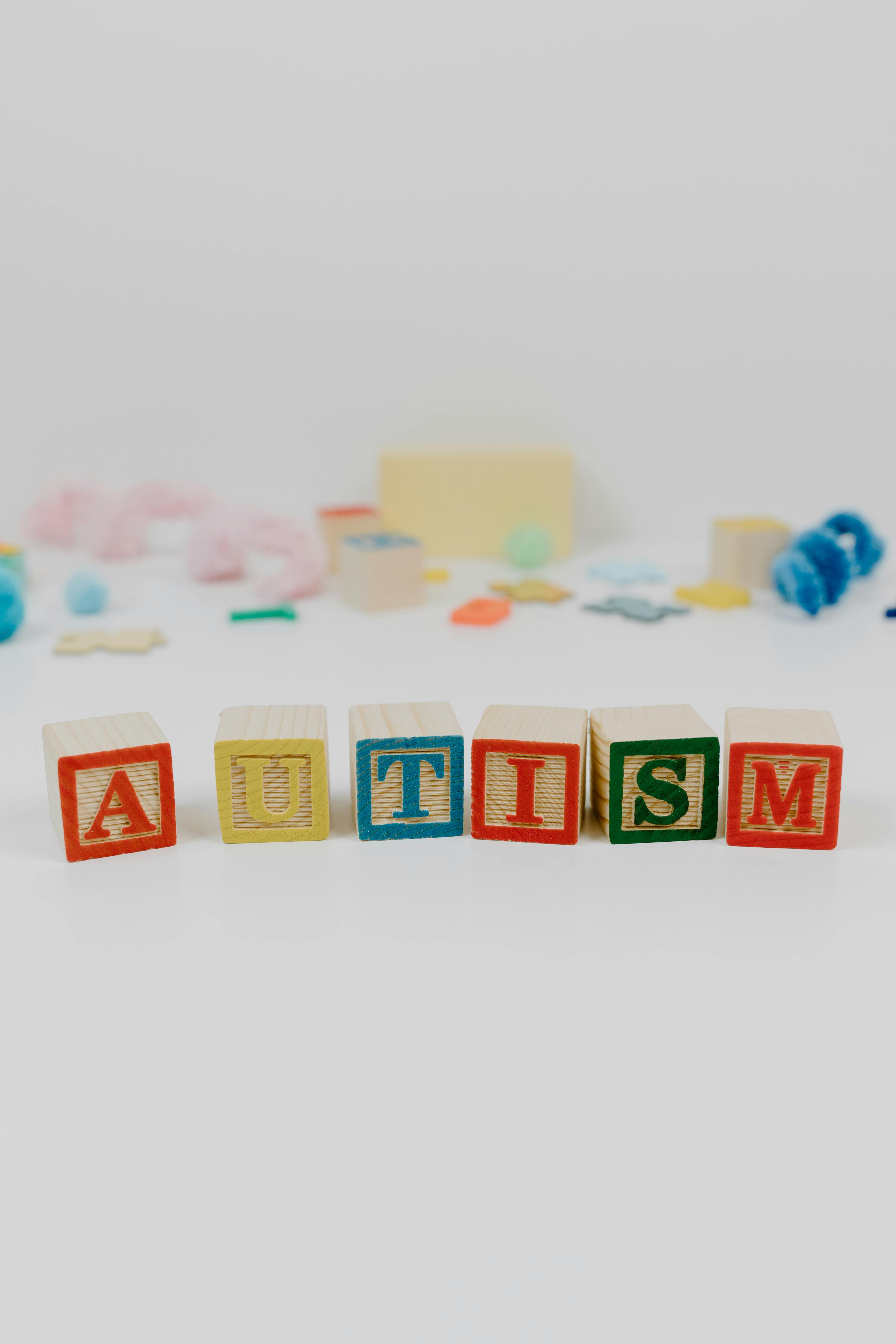 autism spelled using wooden blocks on a white surface