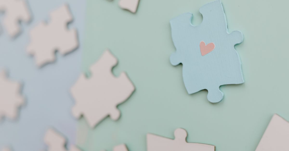 person connecting puzzle pieces with a glowing light between them