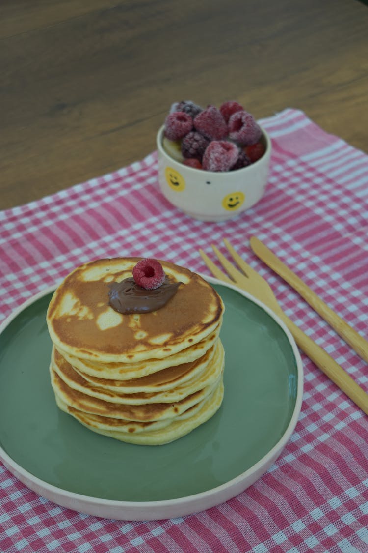 A Stack Of Pancakes On A Green Plate