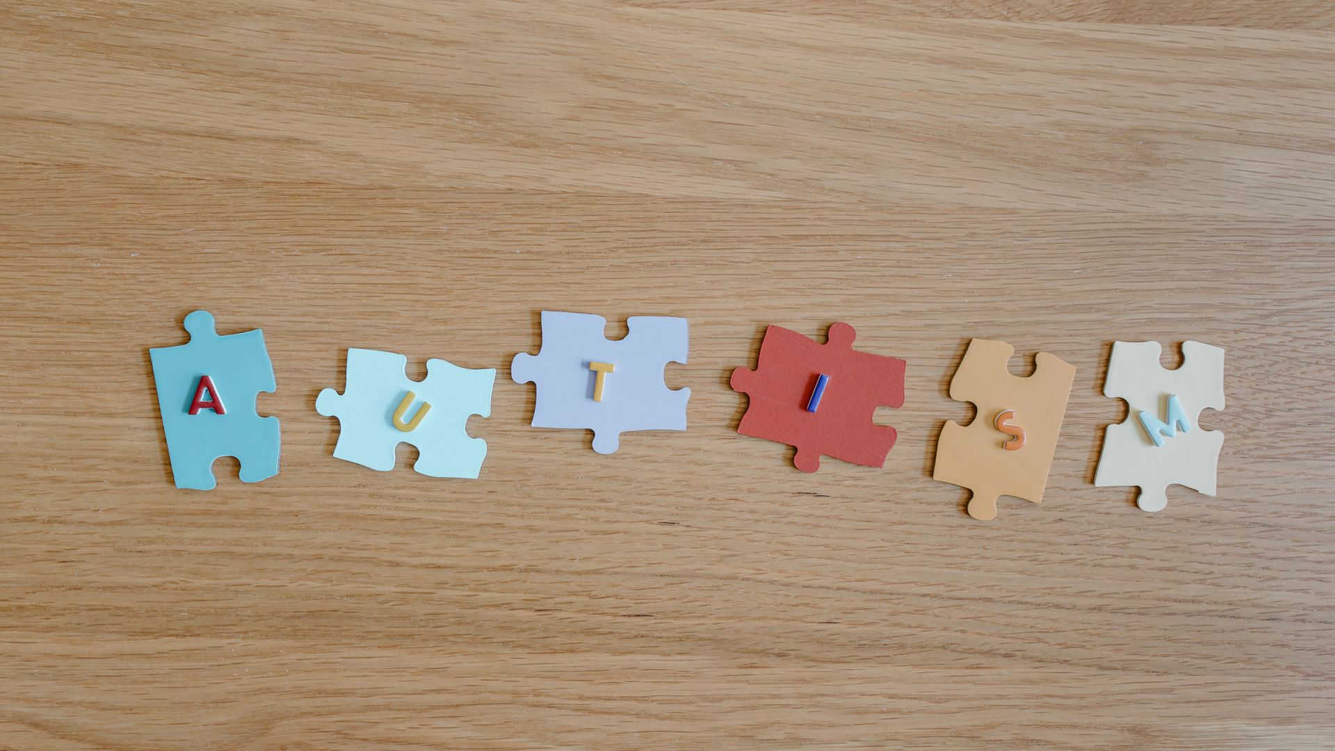 Modafinil for Autism Related Fatigue: An Effective Solution Colorful puzzle pieces spelling 'autism' on a wooden surface, promoting autism awareness — modafinil for autism related fatigue