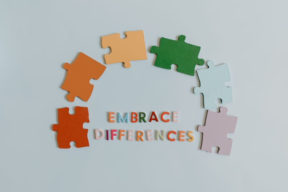 Colorful puzzle pieces and slogan embracing diversity on a white background.
