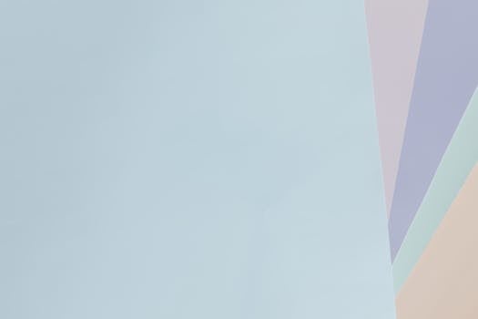 Minimalist pastel abstract background with light blue, purple, and beige shades.