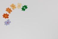 Colorful Puzzle Pieces with a Sign "Autism" Lying on White Background