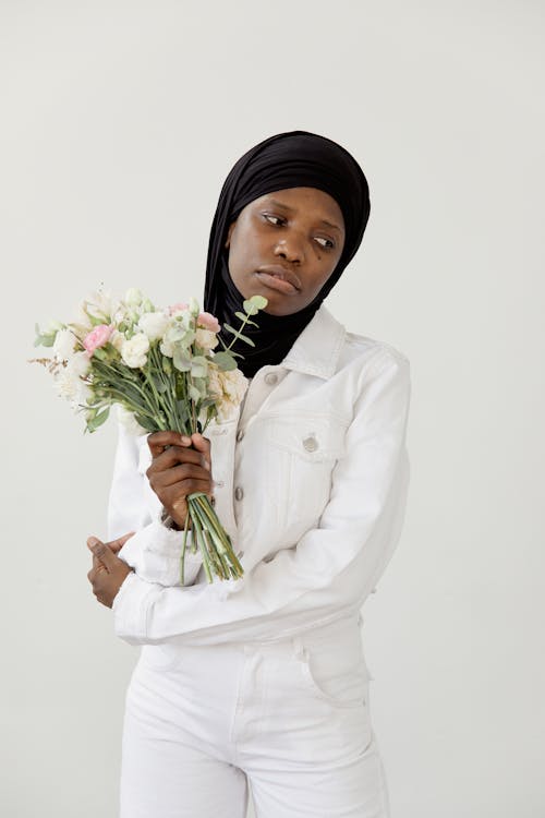 Portrait of a Female Fashion Model Wearing a Hijab and Holding a Bouquet