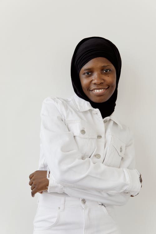A Woman Wearing Black Hijab Standing Near the White Background