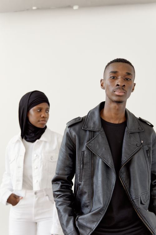 Free Young couple posing confidently in stylish black and white outfits. Stock Photo