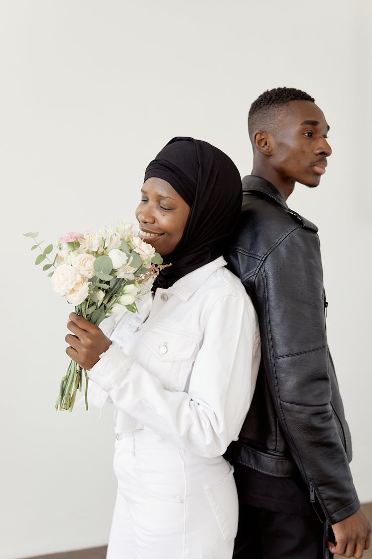 Woman Smelling The Flowers While The Man Is Looking Afar