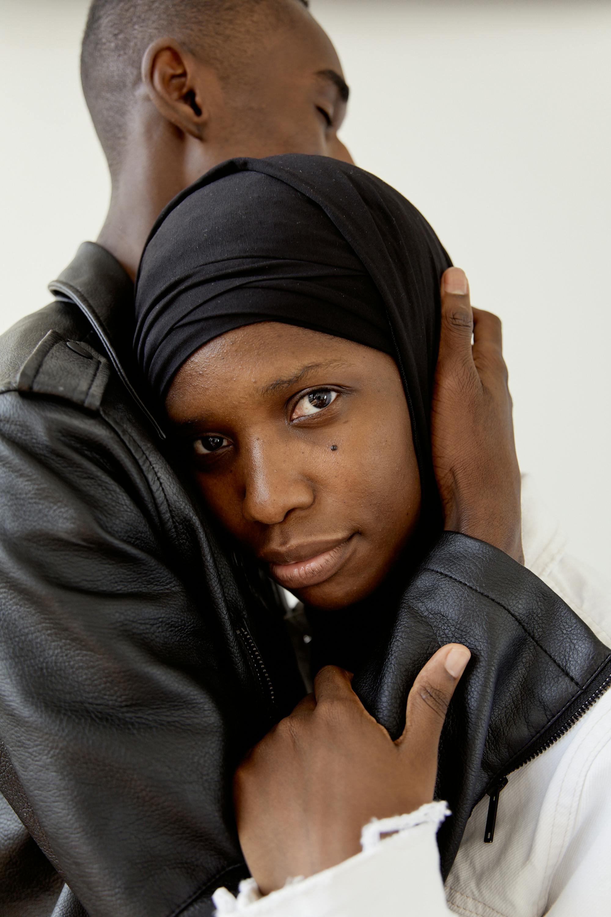 man hugging a woman wearing hijab