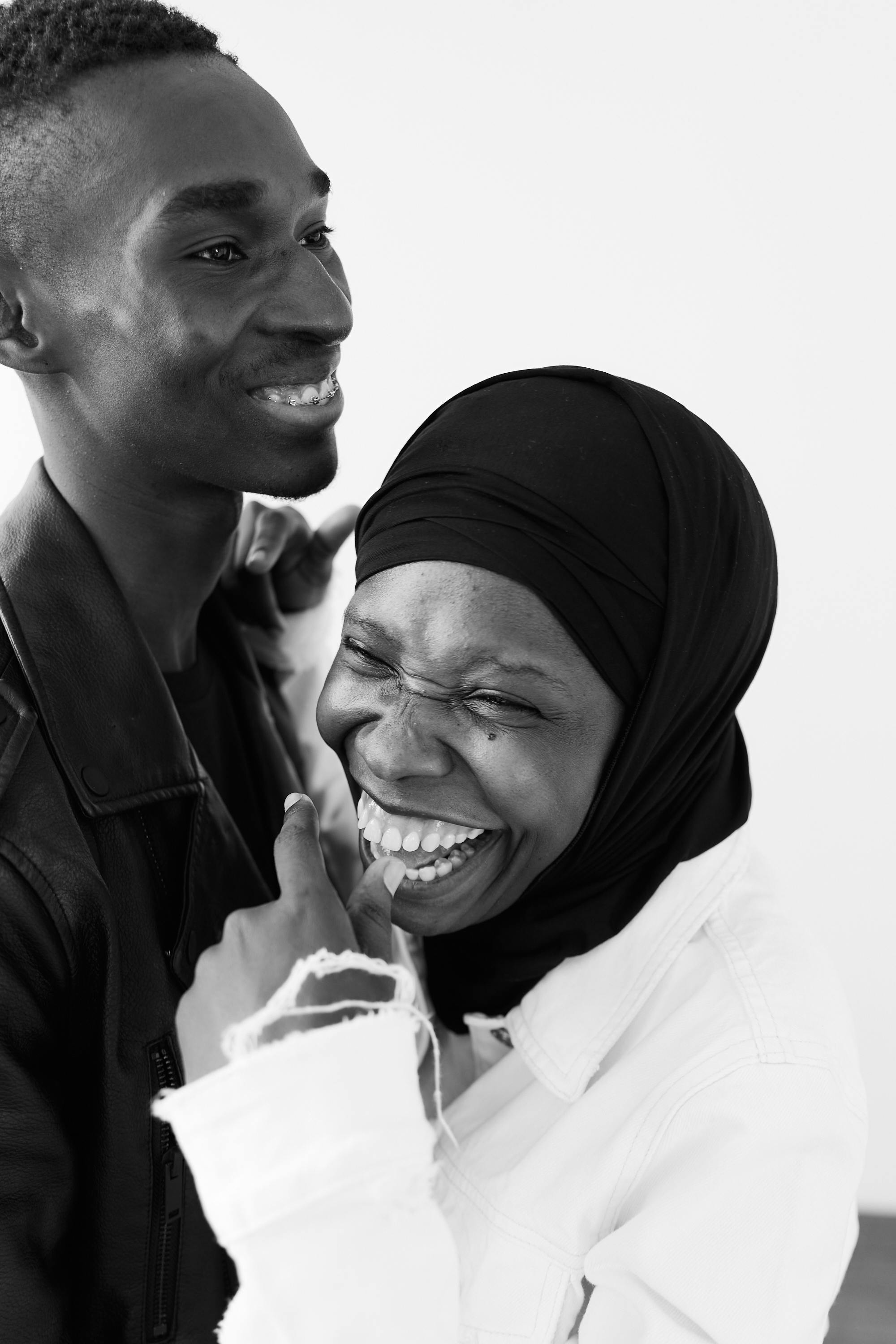 Black and white photo of a happy couple in a cheerful moment, showcasing love and togetherness.