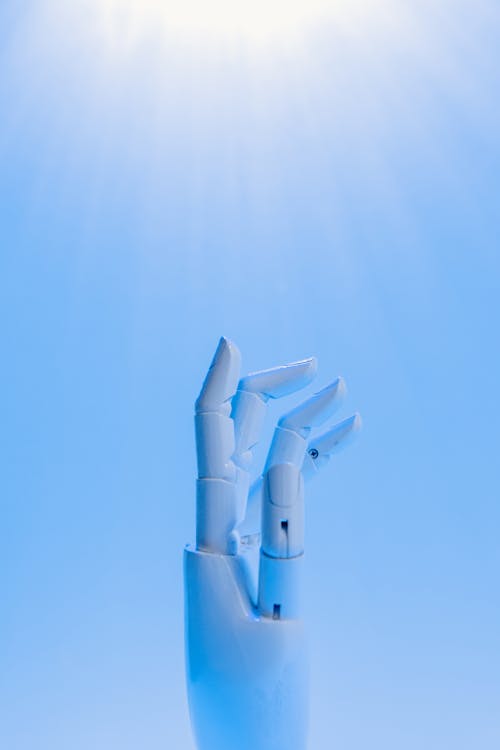 Free Robot's Hand on Blue Background Stock Photo