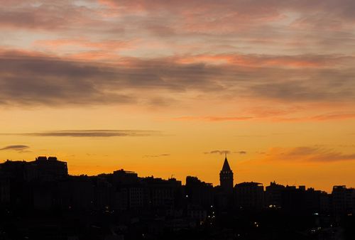 Free Dramatic sunset over city skyline with iconic tower, creating a striking silhouette. Stock Photo