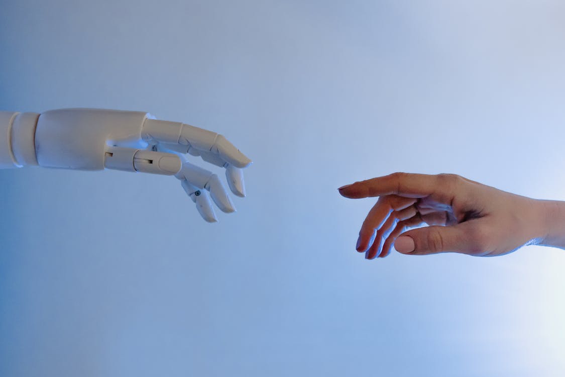 Free Person Reaching Out to a Robot Stock Photo