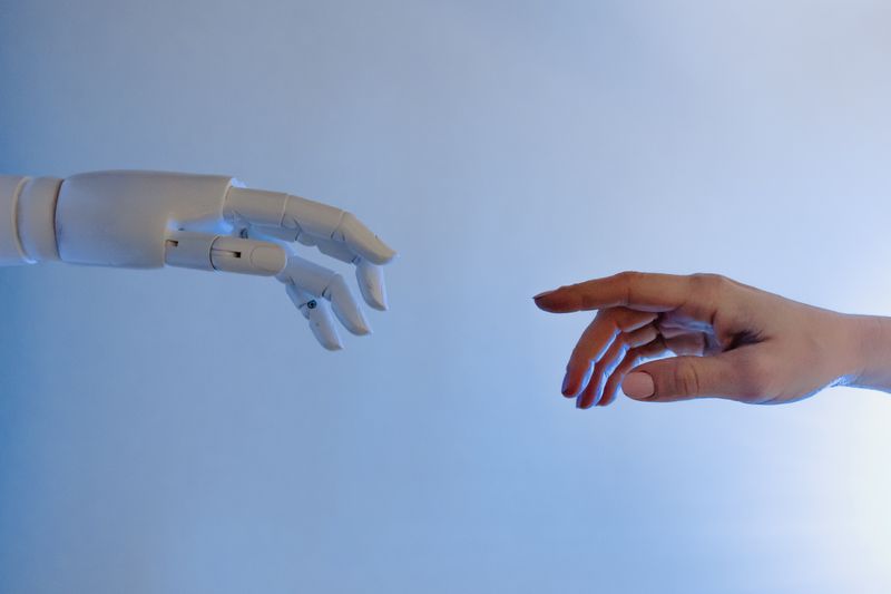 Human reaching out to robotic hand — AI-human collaboration