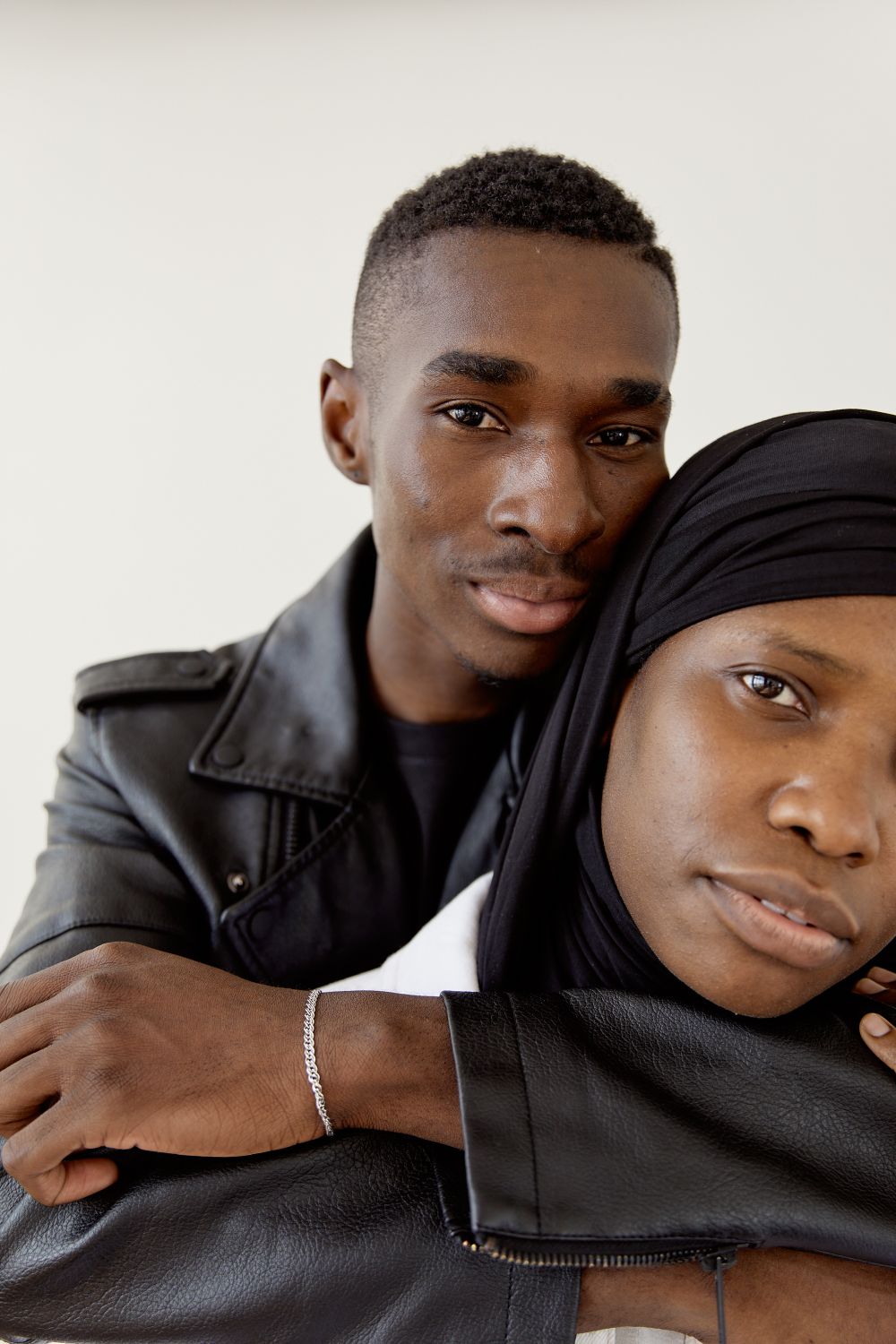 Man in Black Leather Jacket Hugging Woman in Black Hijab · Free Stock Photo