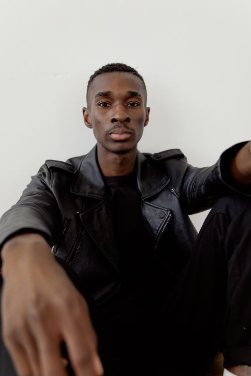 Free Young man posing confidently in a fashionable black leather jacket indoors. Stock Photo