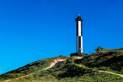 White and Black Lighthouse Under Blue Sky