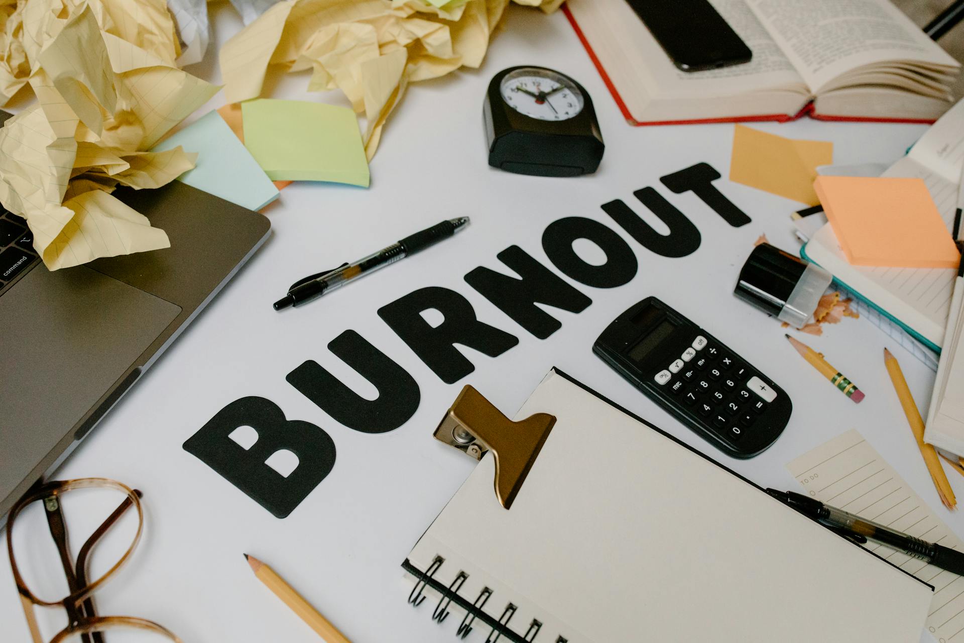 Black Letters surrounded with Office Supplies and Crumpled Papers